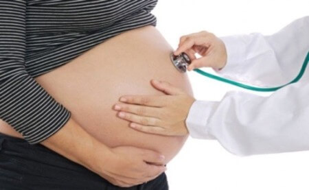 Médico inspeccionando los latidos del corazón del bebé