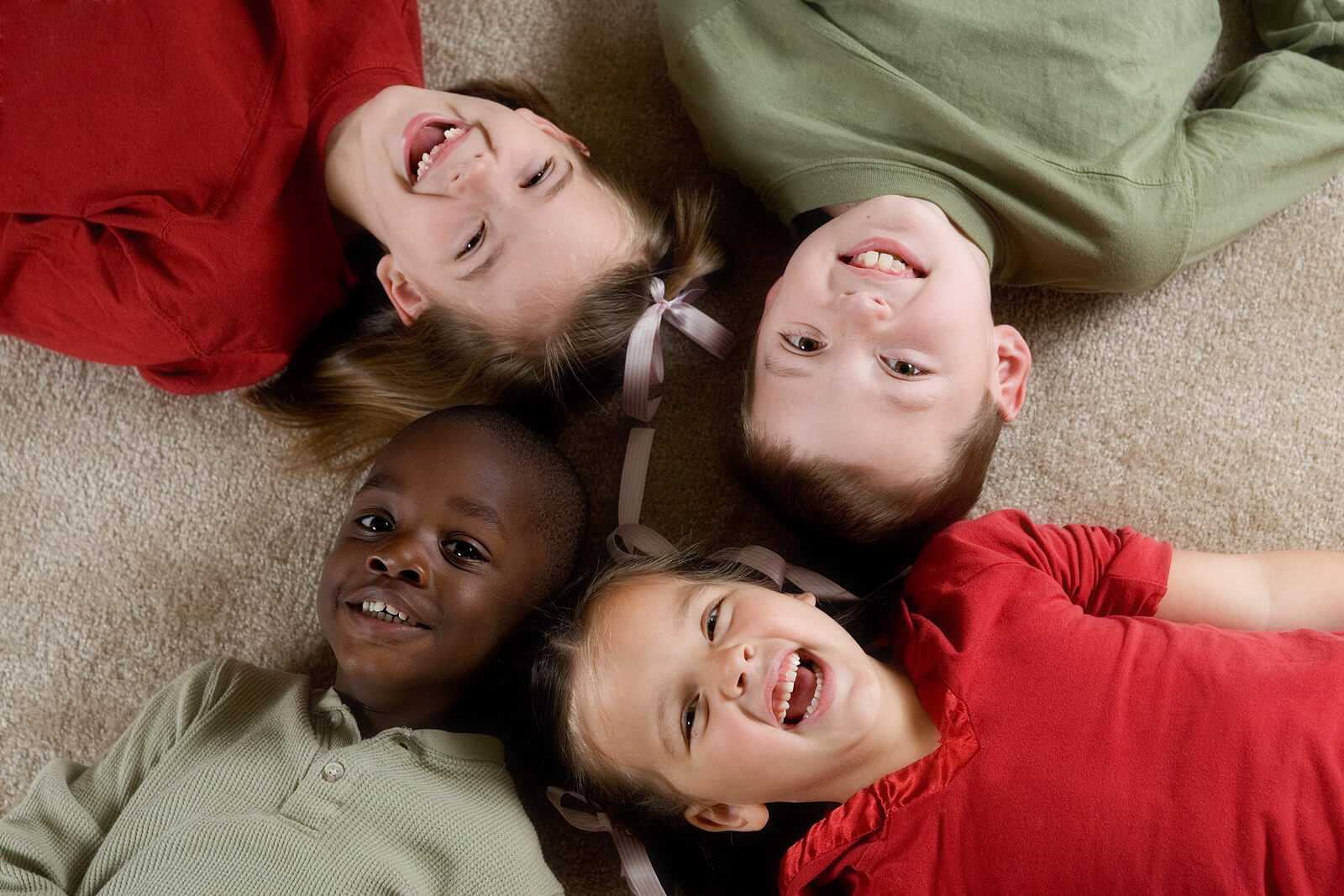 Des enfants allongés qui sourient.
