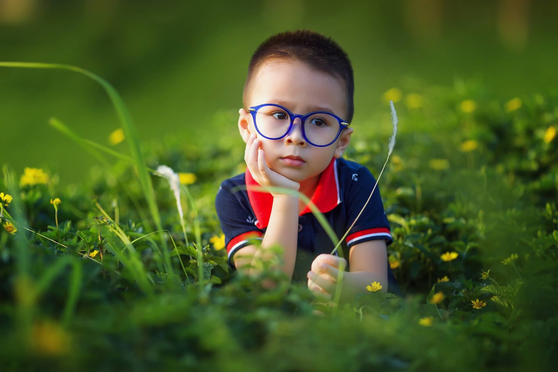 menino de 4 anos entediado no jardim