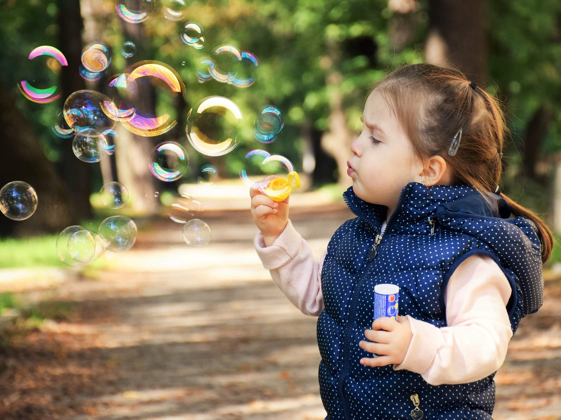 menina fazendo bolhas de sabão ao ar livre