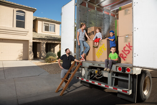 Familia subiendo sus cosas al camión de mudanza para cambiar de casa