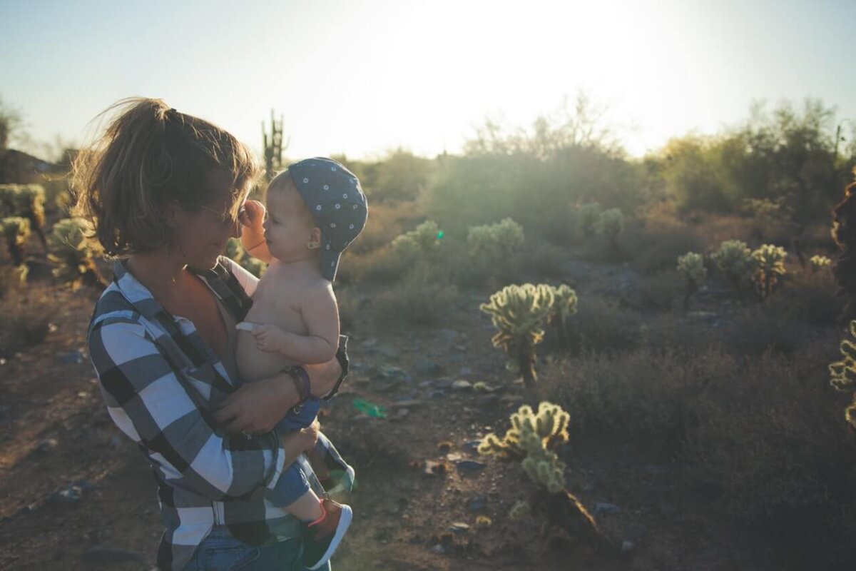 Madre con camisa de cuadros en el campo con su bebe