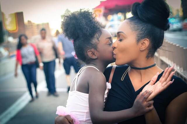 Madre dando un beso a su hija