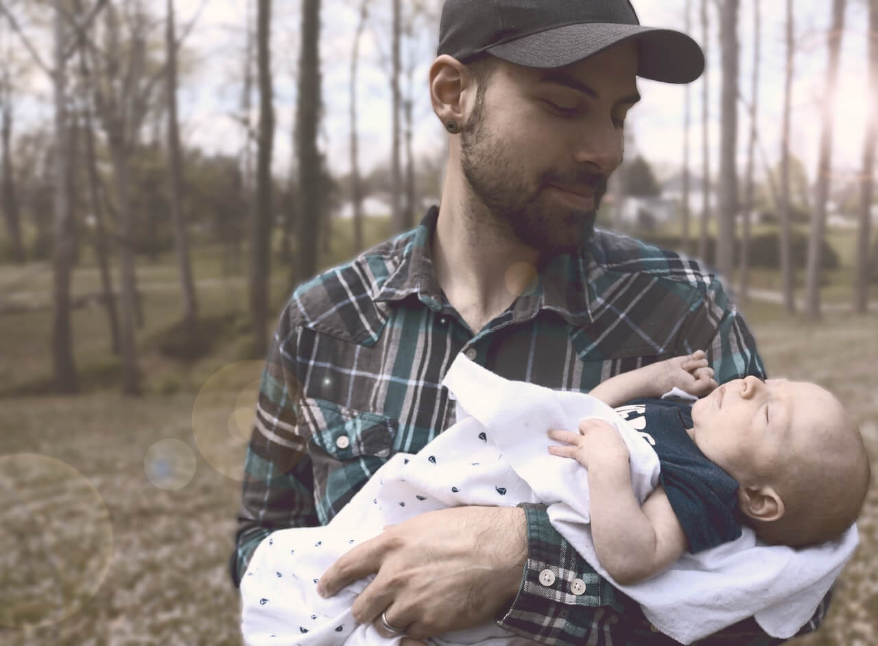 Padre con gorra con su bebe recien nacido