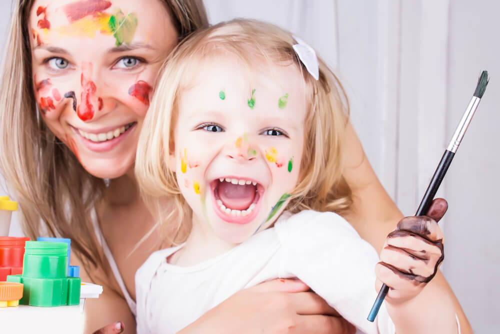 Madre e hija con la cara manchada de pintura