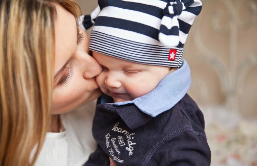 Madre dando un beso a su niño pequeño