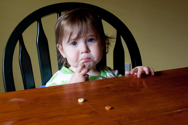 Un jeune enfant triste à table.