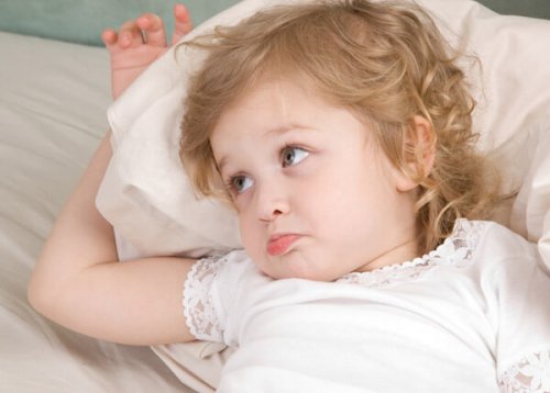 Niña despierta en la cama