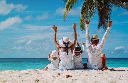 Padres con sus hijos en la playa disfrutando de las vacaciones.