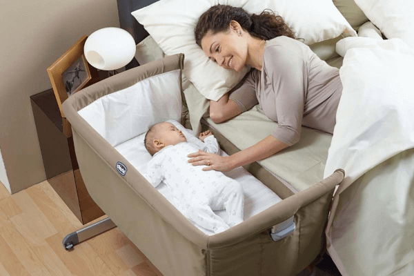 Madre con il suo bambino nel lettino che dorme insieme