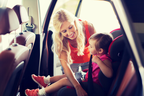 Mère attachant une ceinture de sécurité à son fils dans son siège auto