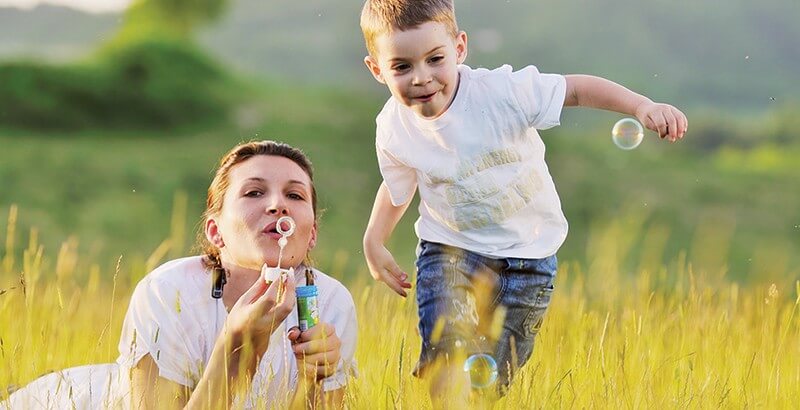 Madre e hijo en el campo haciendo pompas