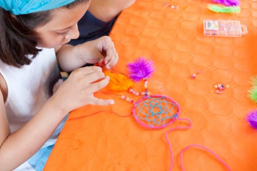 Una pequeña elaborando su propio atrapasueños