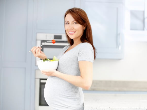 Mujer embarazada comiendo una ensalada