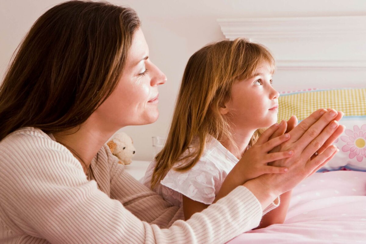 Madre e hija rezando antes de ir a dormir