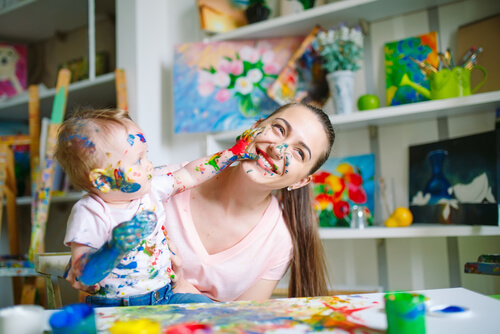 Un enfant qui fait de la peinture avec ses doigts.