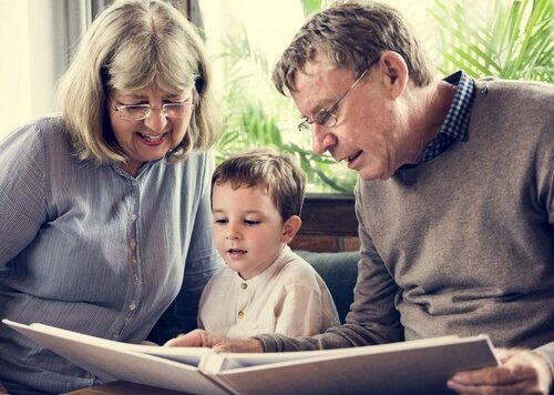 Abuelos leyendo cuentos infantiles a su nieto.