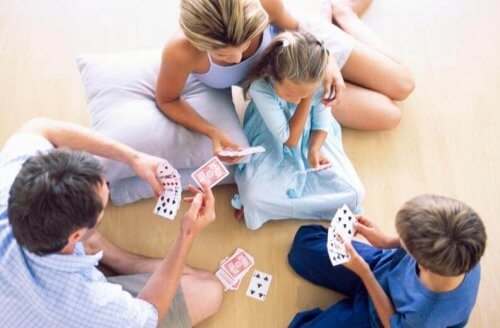 Familia jugando a las cartas con mucho amor.