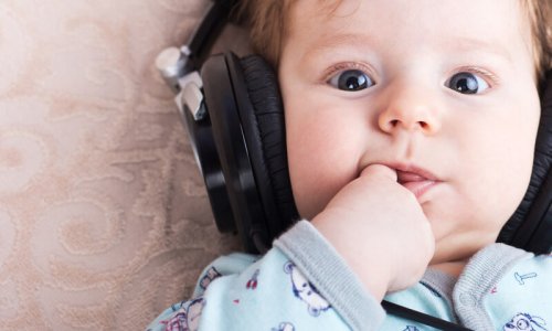 En bebis som bär hörlurar.