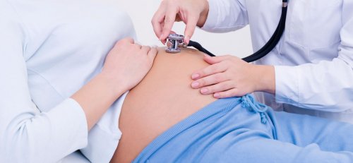 Un obstetra realizando un examen medico a una embarazada