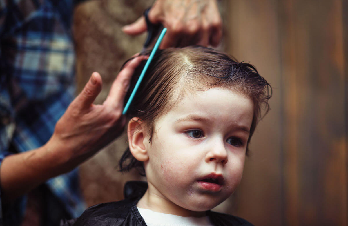 Niño recibiendo un corte de cabello tipo clásico.