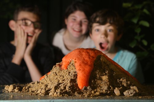 Trois enfants devant une expérience scientifique.