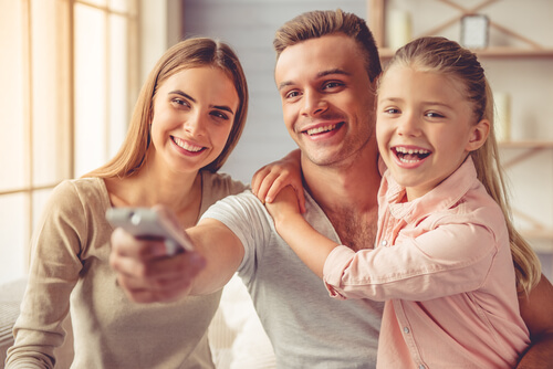 Une famille partage devant la télé avec des dessins animés