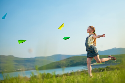 A girl running freely in an open field.