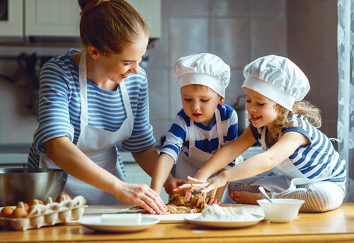 Madre e hijos preparando masa para galletas en la cocina.