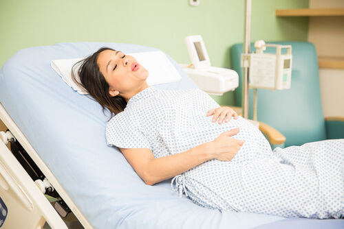 Mujer en labor de parto haciendo respiraciones profundas.