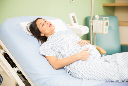 A woman on a hospital bed experiencing contractions.