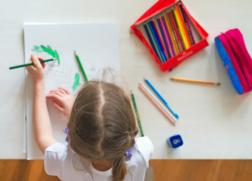 Una niña coloreando está desarrollando sus habilidades motrices finas.