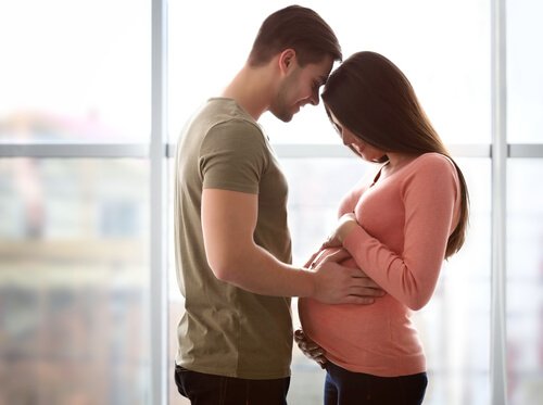 Hombre abrazando la barriga de su mujer durante el embarazo.