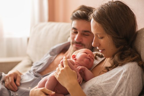 Padres con su bebé recién nacido aplicando la maternidad consciente.