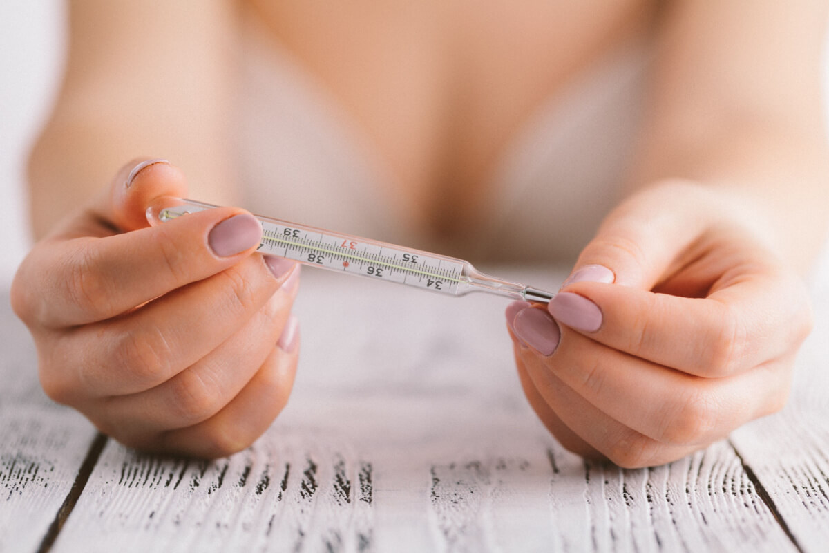 Mujer midiendo su temperatura basal en el embarazo.