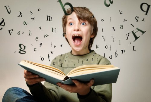 An excited child looking at letters popping out of a book.