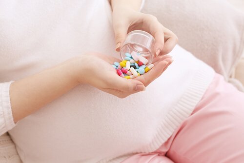 A woman pouring pills inter her hand.