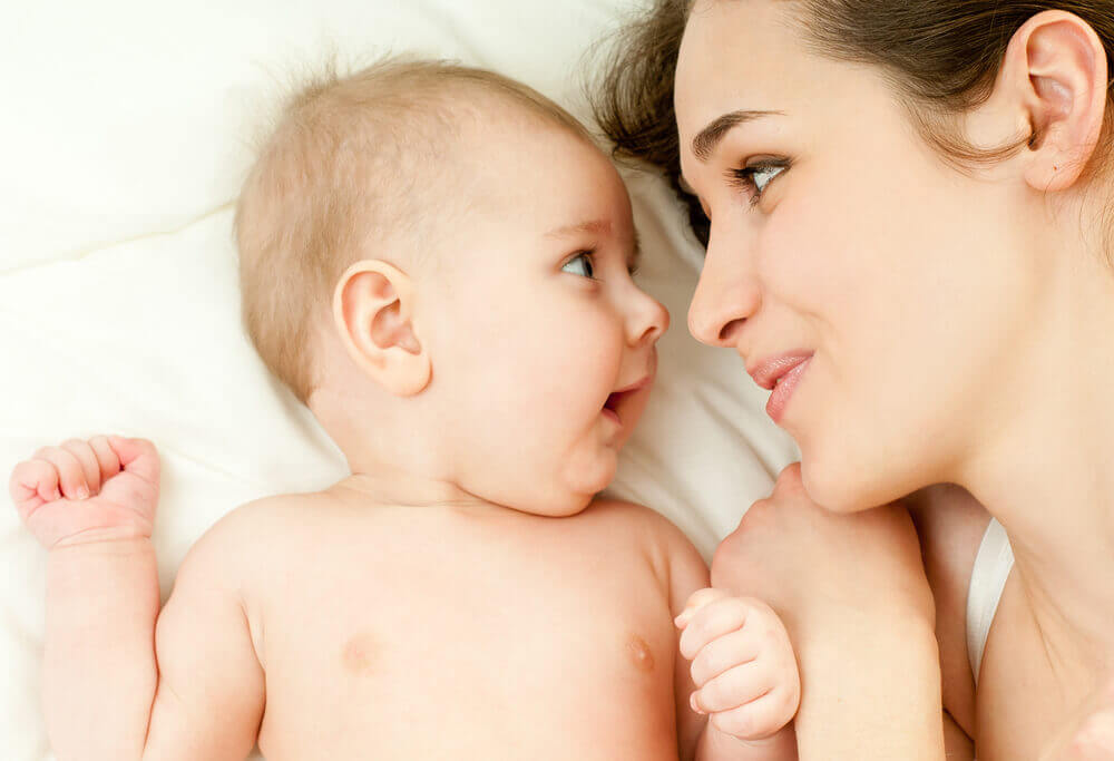 Une mère et son bébé qui se regardent dans les yeux.