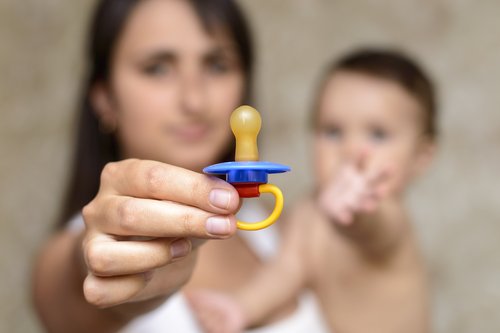Gros plan sur une tétine devant une mère et son fils.