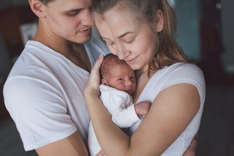 Padres con su bebé en brazos tras el nacimiento de su hijo.