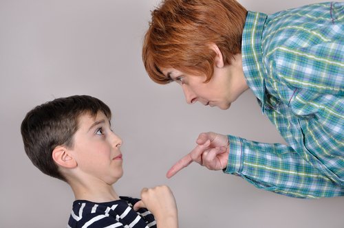 Madre amenazando a su hijo con un castigo positivo o negativo.