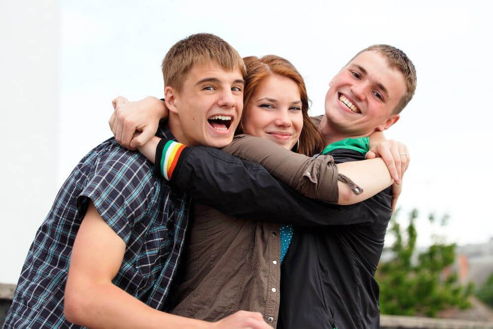 Tres amigos adolescentes abrazados