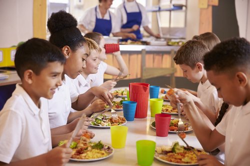 Niños comiendo en el comedor escolar.
