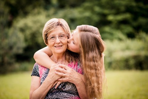 Nieta dando un beso a su abuela con Alzheimer.