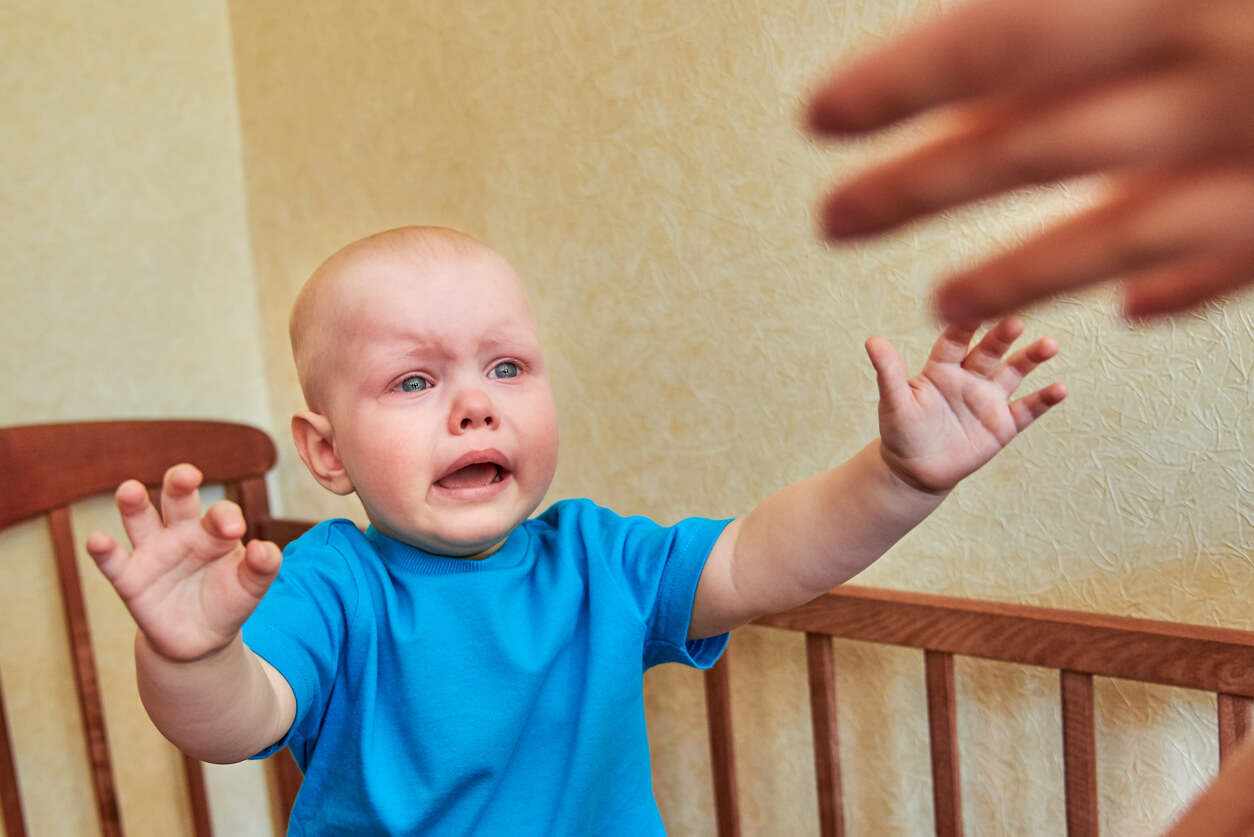 nino levanta brazos pide upa a la mama en la cuna llorando