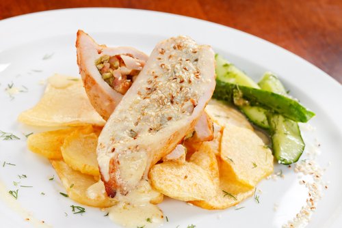 Une assiette avec du poulet et des pommes de terre et des courgettes.