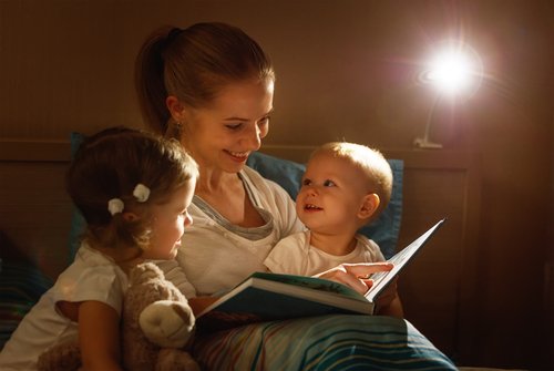 Madre leyendo un cuento a sus hijos antes de dormir.