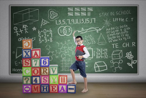 Niño delante de una pizarra con muchas fórmulas para su aprendizaje significativo.