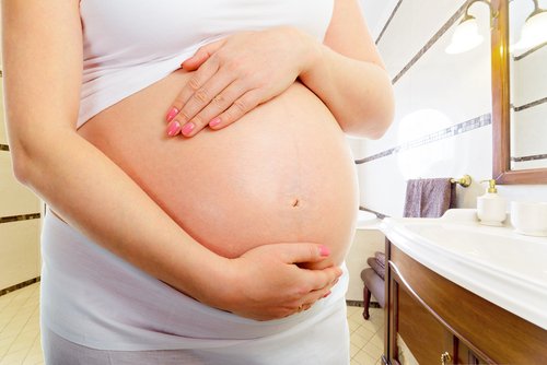 Mujer embarazada tocándose la barriga y pensando en el tapón mucoso.