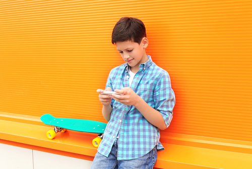 Niño con el teléfonos jugando a apps infantiles para aprender matemáticas.